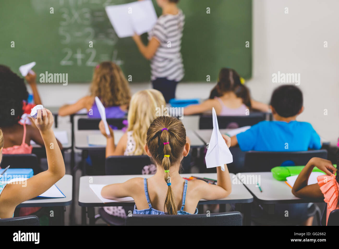 Schulkinder mit Papierflieger im Klassenzimmer Stockfoto