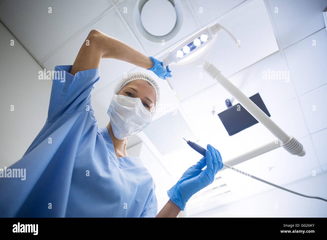 Zahnarzthelferin in OP-Maske hält Dentalwerkzeuge Stockfoto