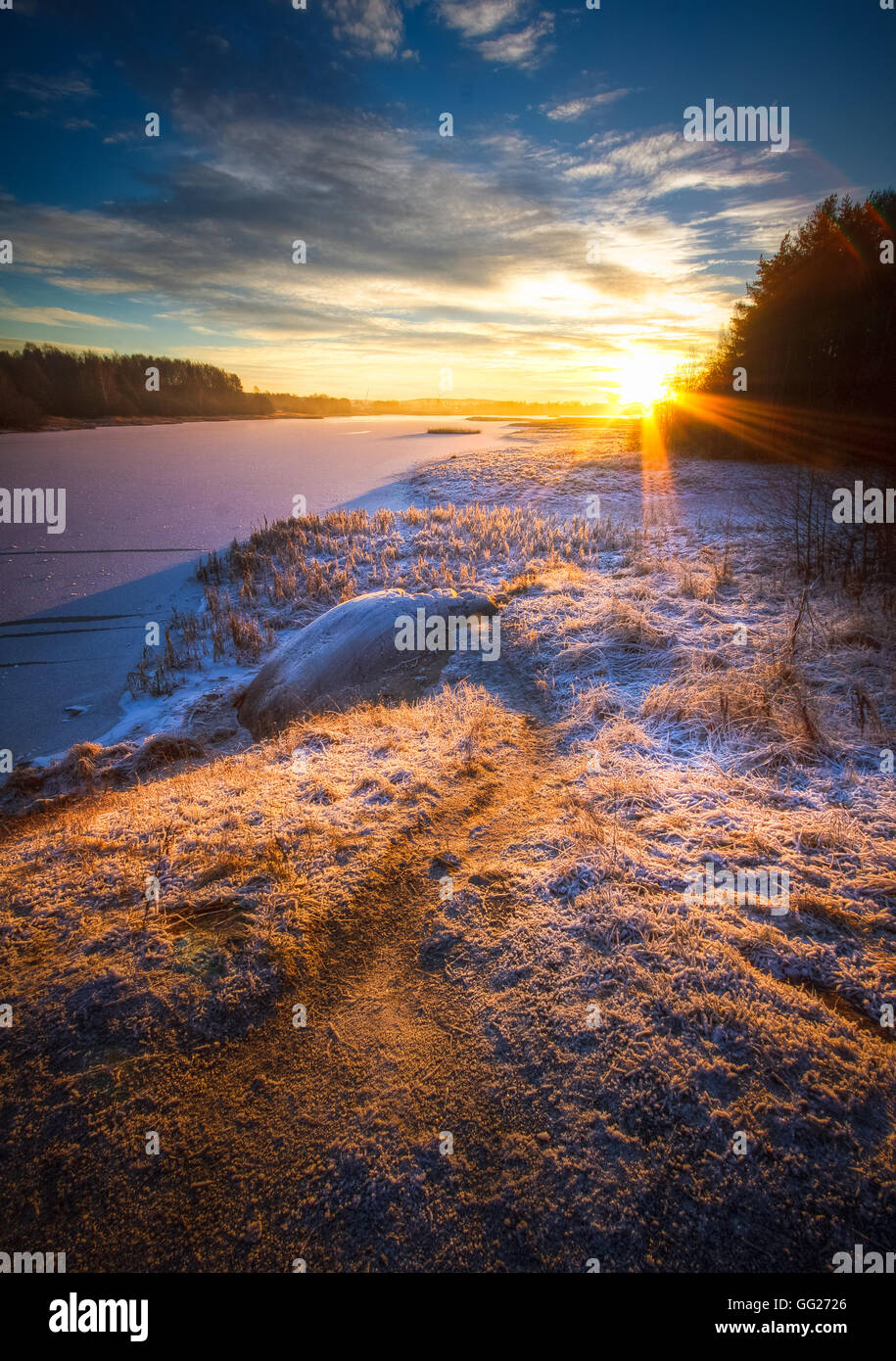 Tiefstehende Sonne Am Horizont Lange Schatten Im Vordergrund Frost Und Schnee Vereisten Fluss Auf Der Linken Seite Warme Tone Gefrorenen Boden Stockfotografie Alamy