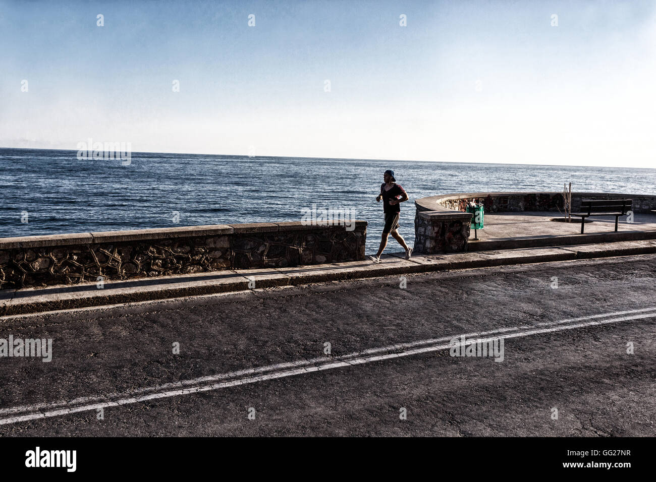 Ein Mann, der allein auf der Straße am Meer entlang läuft, Rethymno, Kreta, Griechenland Stockfoto