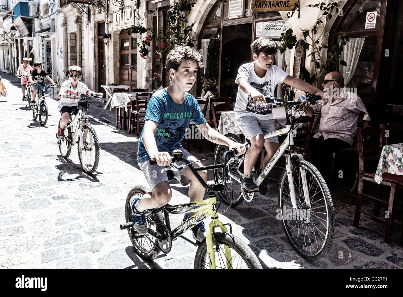 Junge Jungs auf Fahrrädern in den Straßen von Rethymno, Kreta, Griechenland Stadtmenschen fahren mit Kindern auf Radtouren, Fahrrädern Straßenjungen Stockfoto