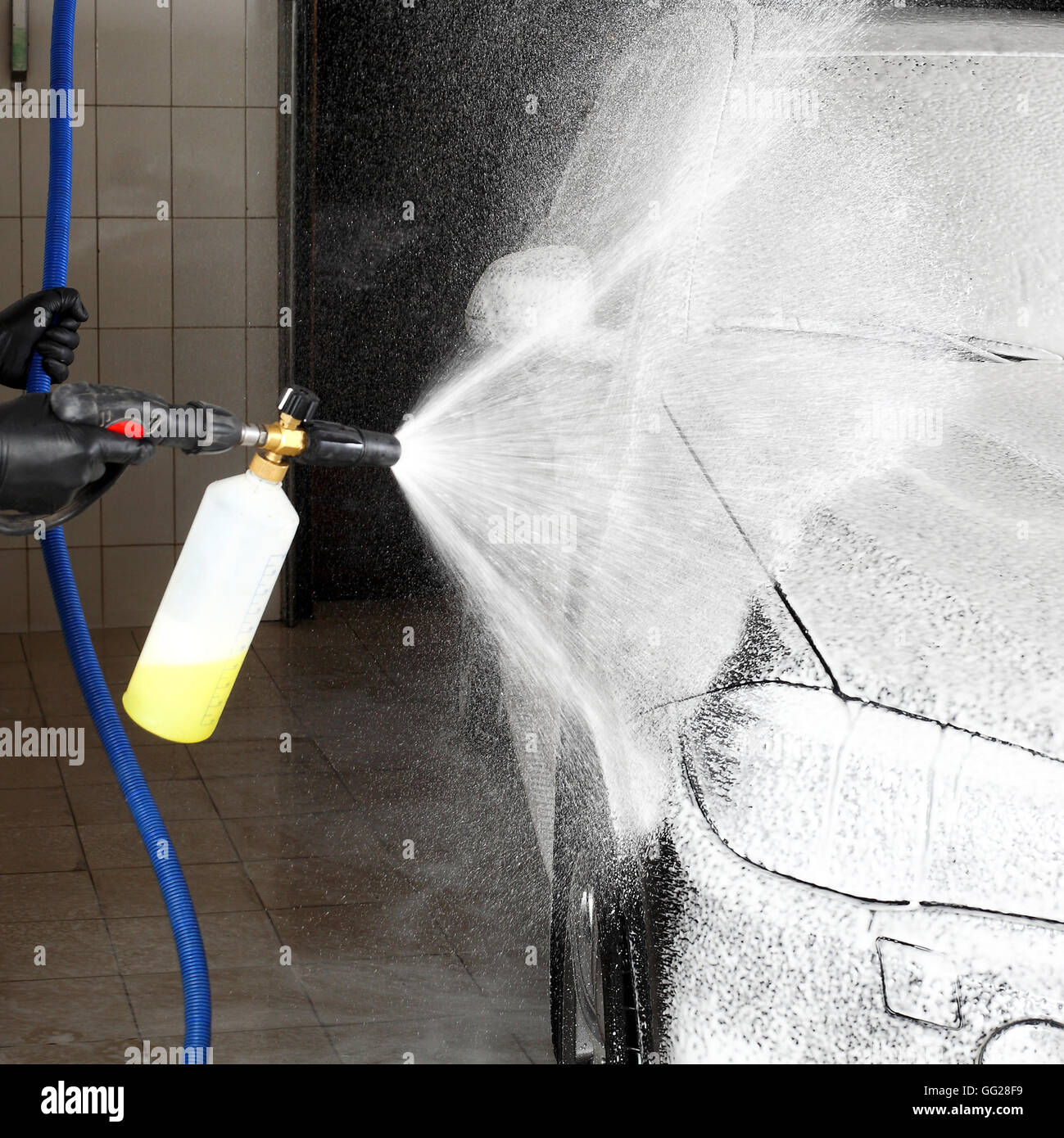 Die Arbeitskraft, das Waschen des Autos unter hohem Druck. Auto-Service. Stockfoto