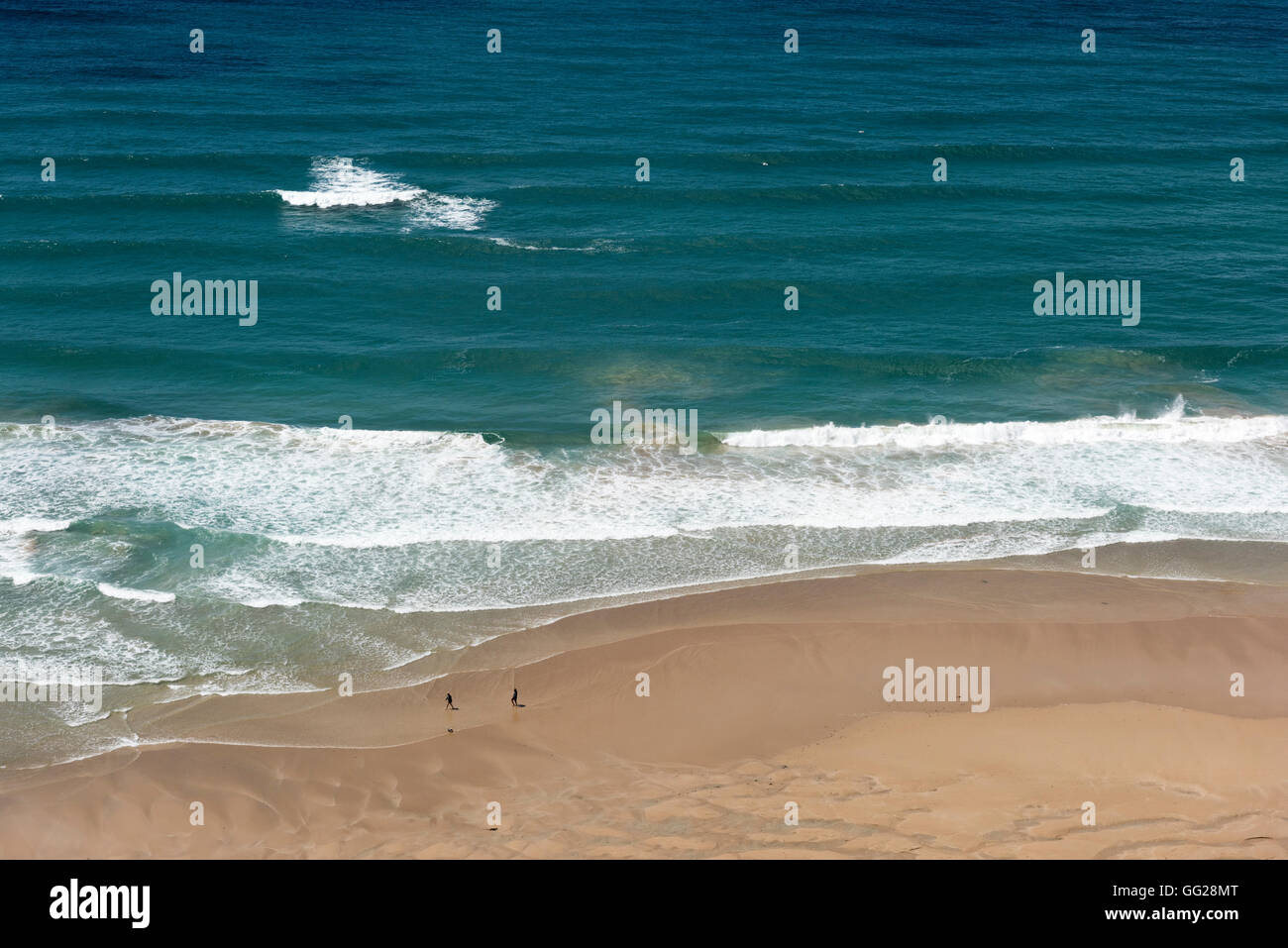 Zwei Menschen in der Ferne zu Fuß am Strand von Bedruthan Cornwall UK in einem weiten, offenen Raum im freien Stockfoto