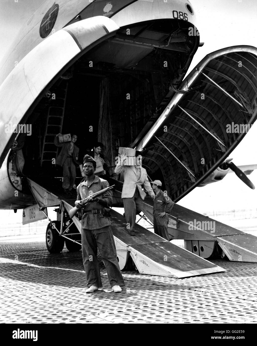 Auf einem Flughafen in Indochina, französische Personal aussteigen ein C124 'Globemaster' Douglas von der US Air Force. Ein Soldat hält Uhr 3. Mai 1954 Krieg in Indochina U.S. Air Force Photo Stockfoto