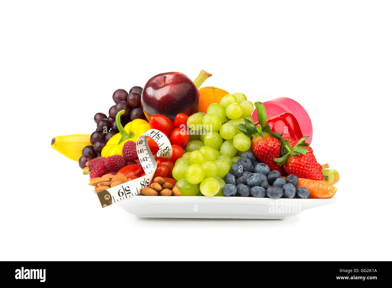 Gesunde Ernährung & Lifestyle auf einen Teller Obst Gemüse Nüssen Maßband Hand Gewicht Stockfoto