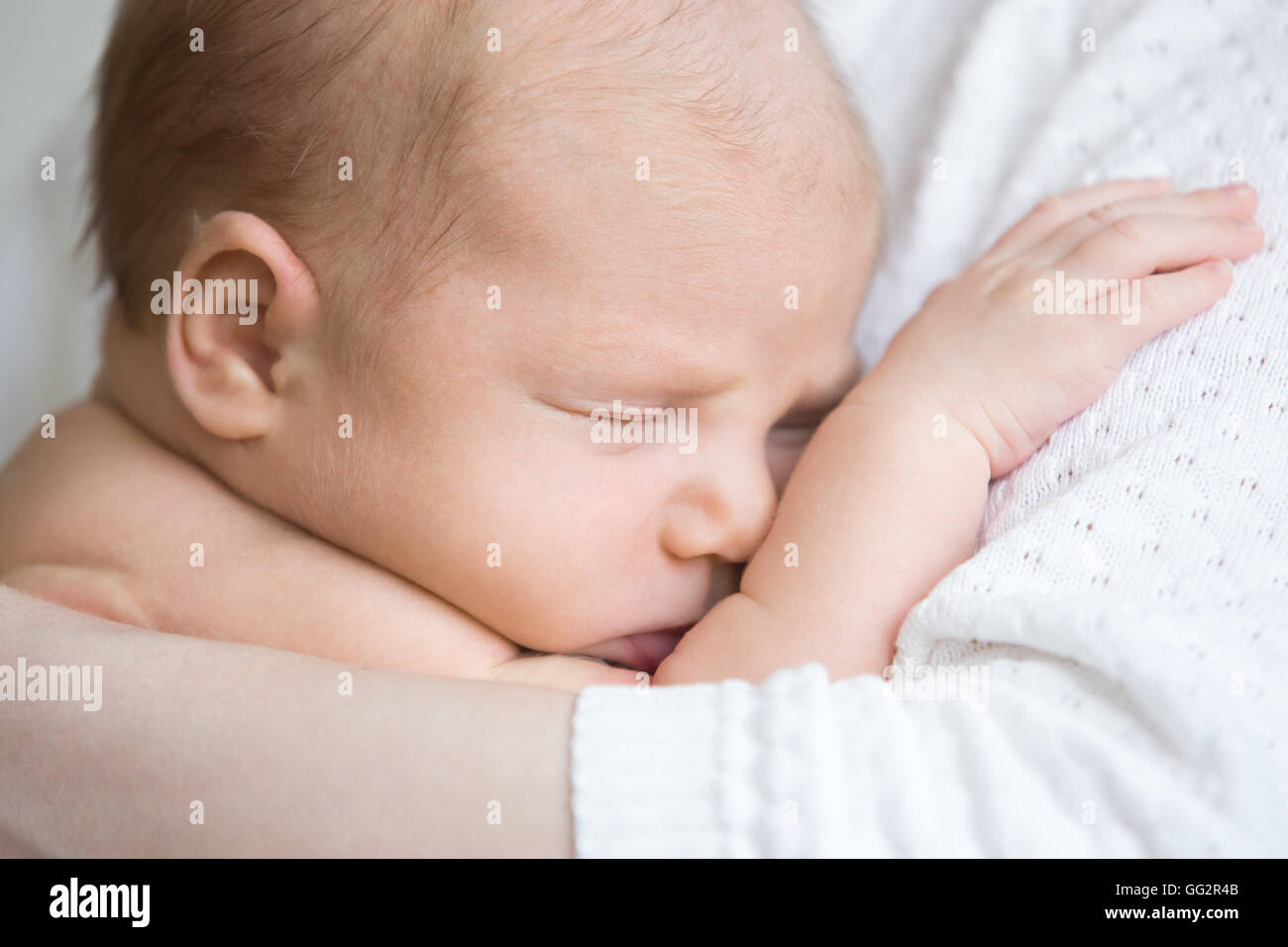 Close-up Portrait von lustigen neugeborenen Baby Nickerchen im Mom Arme. Entzückende Neugeborene schlafen auf Mama Hände. Gesundes Kind Stockfoto