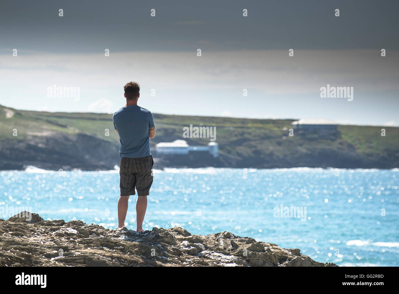 Ein Urlauber stehen auf der Landzunge in Newquay, Blick auf das Meer Stockfoto