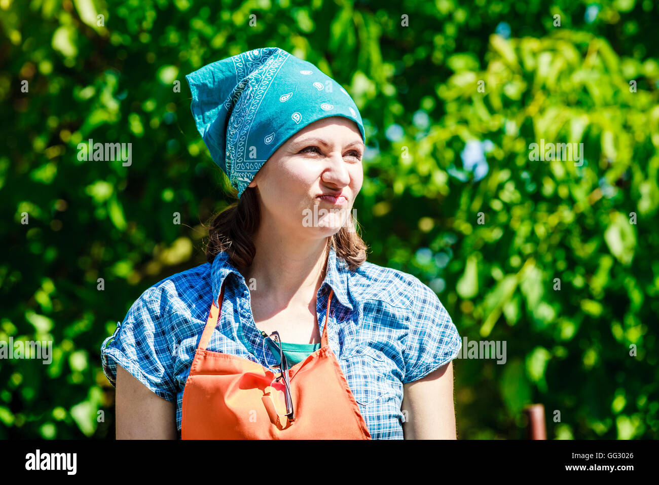 Reife lustige Bäuerin Kopftuch Schürze Hut im Garten Stockfotografie - Alamy