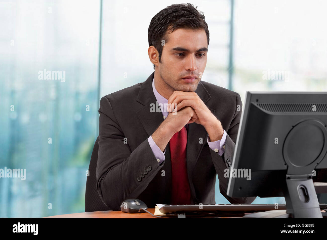 Geschäftsmann sucht am Bildschirm im Büro Stockfoto