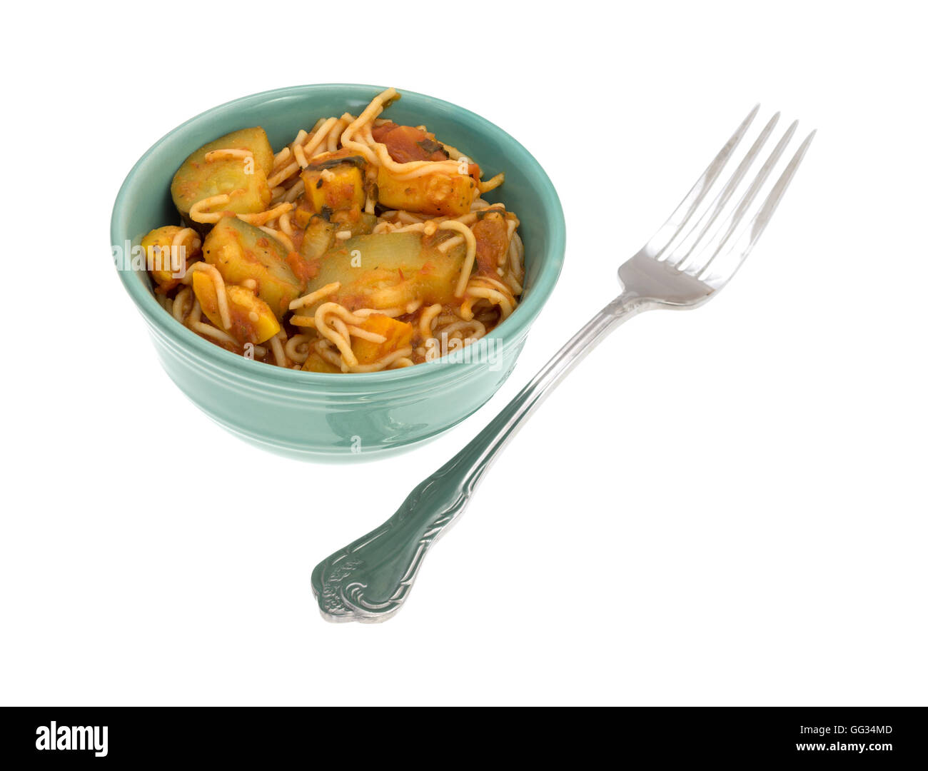 TV Dinner Engel Haar Nudeln mit Zucchini und Spinat in eine kleine grüne Schüssel mit einer Gabel auf die Seite auf einem weißen Hintergrund. Stockfoto