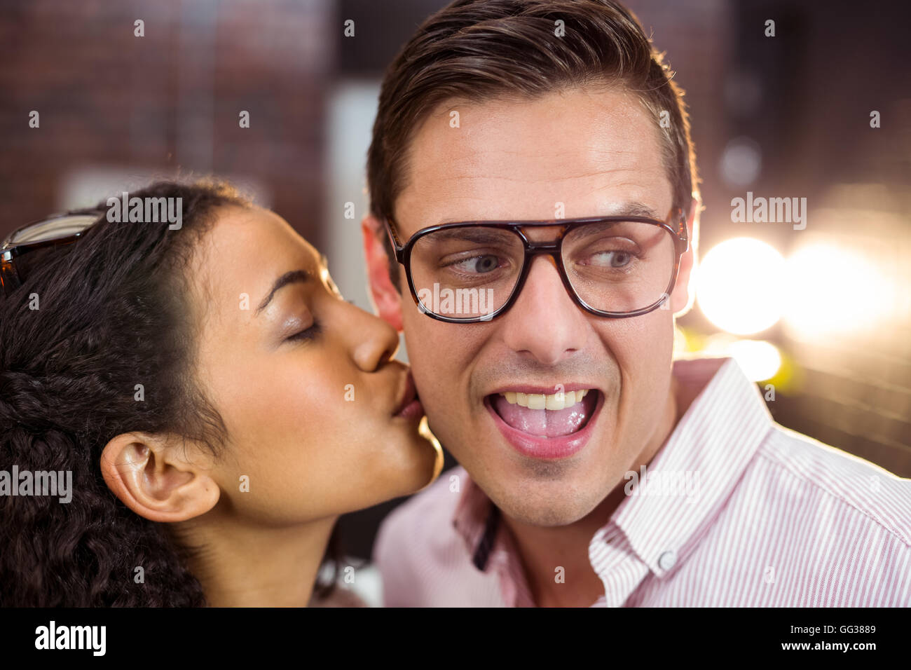 Frau küssen Mann auf Wange Stockfoto