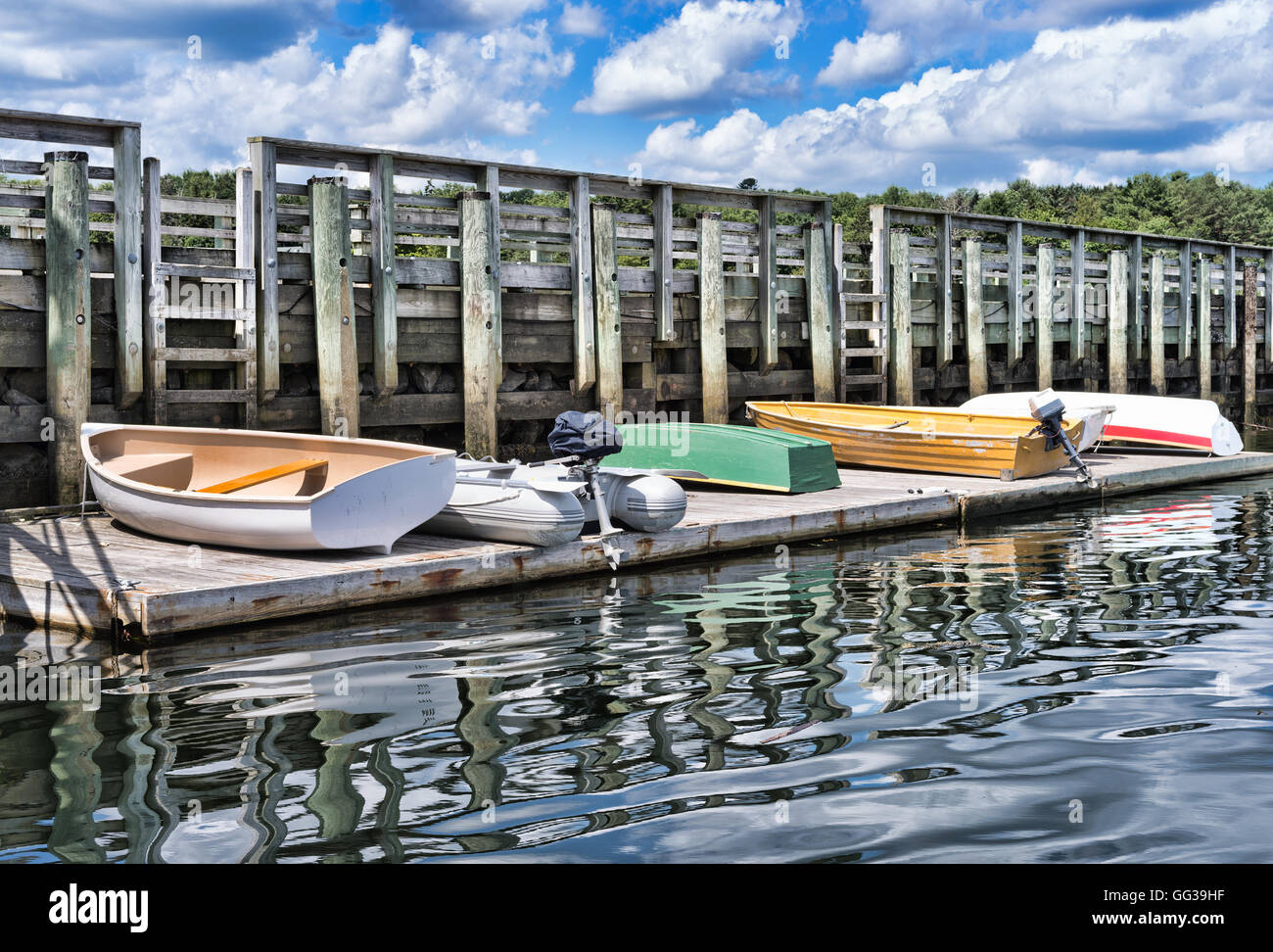 Mehrere Holz und Kautschuk Skiffs mit Motoren auf ein Schwimmdock an Searsport, Maine Stockfoto