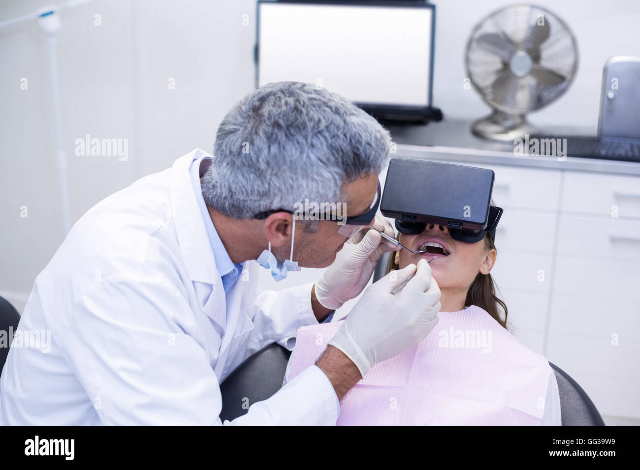 Zahnarzt untersuchen Patientin mit Dentalwerkzeuge Stockfoto