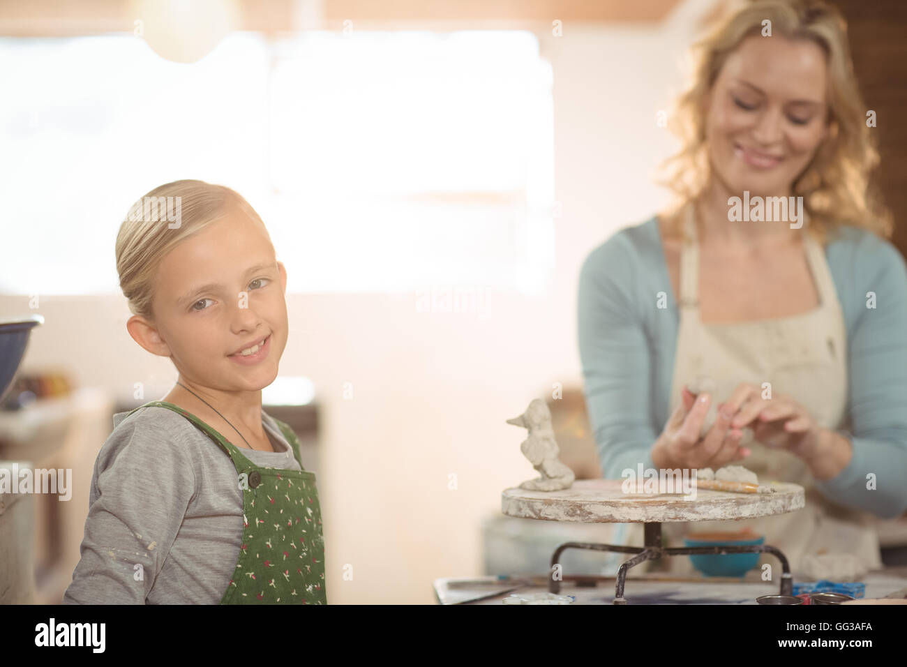 Weibliche Potter und Mädchen arbeiten in Werkstatt Stockfoto