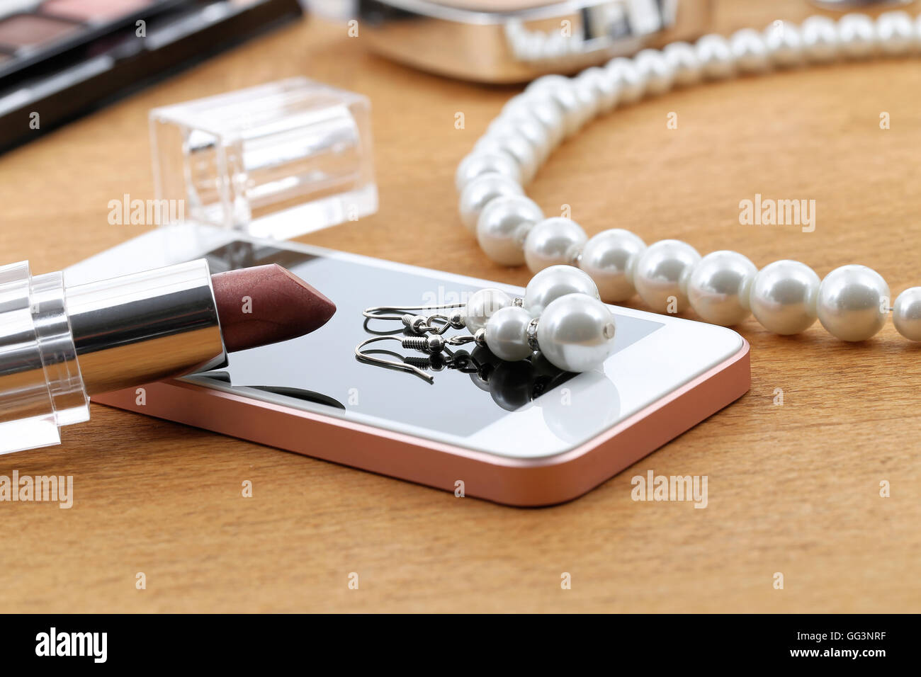 Kosmetik, Telefon und Schmuck auf einem Tisch nach party Stockfoto