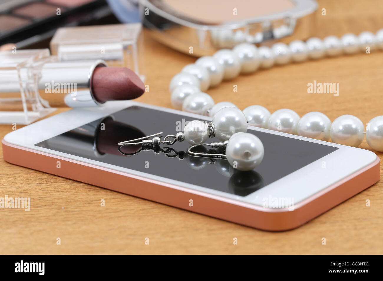 Kosmetik, Telefon und Schmuck auf einem Tisch nach party Stockfoto