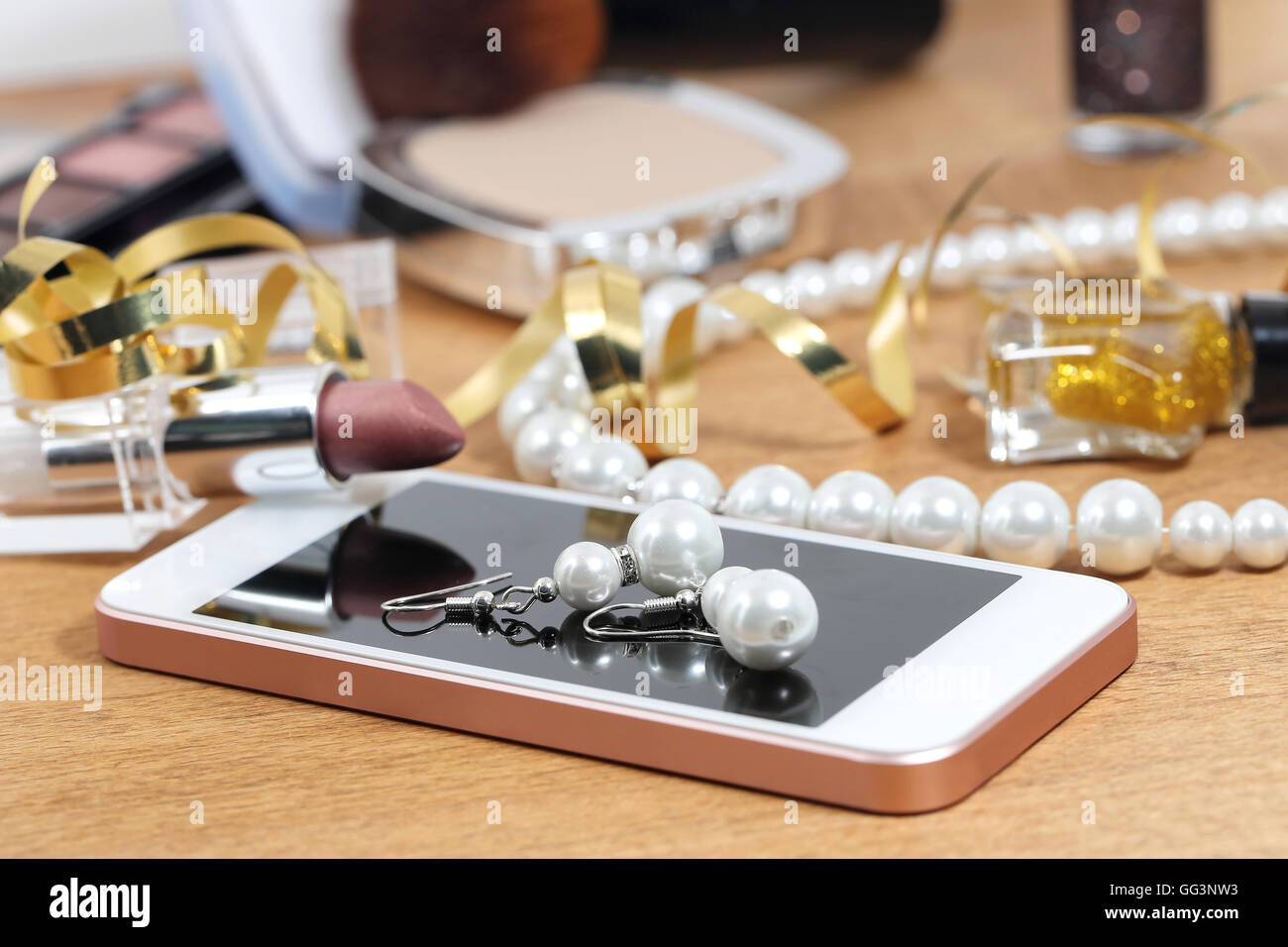 Kosmetik, Telefon und Schmuck auf einem Tisch nach party Stockfoto