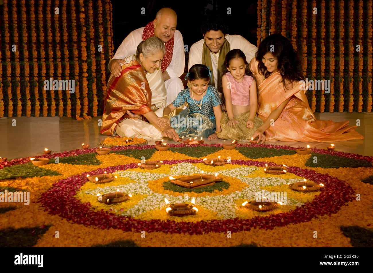 Familie sitzt in der Nähe von rangoli Stockfoto