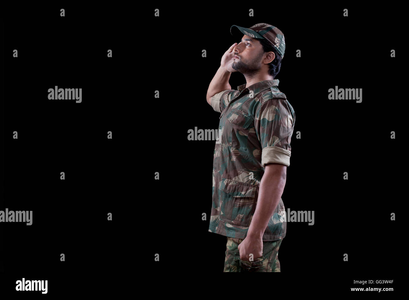 Männlichen militärischen Soldaten salutieren vor schwarzem Hintergrund Stockfoto