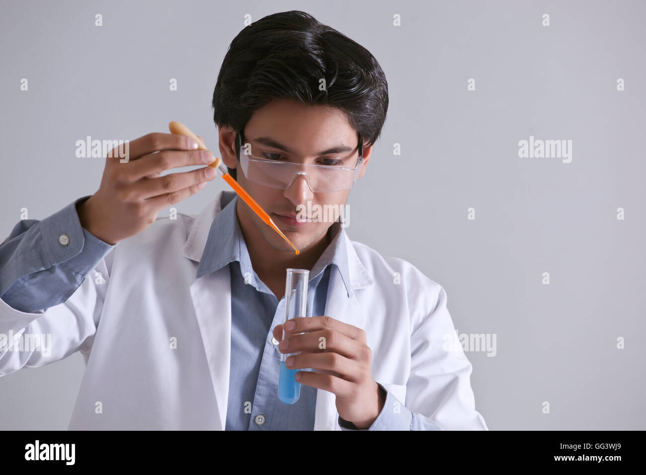 Junge Wissenschaftler, die Zugabe von Flüssigkeit in das Teströhrchen Stockfoto
