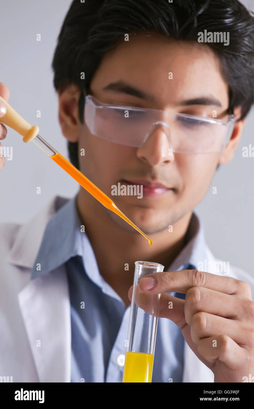 Zuversichtlich männliche Wissenschaftler, die Zugabe von Flüssigkeit in das Teströhrchen Stockfoto