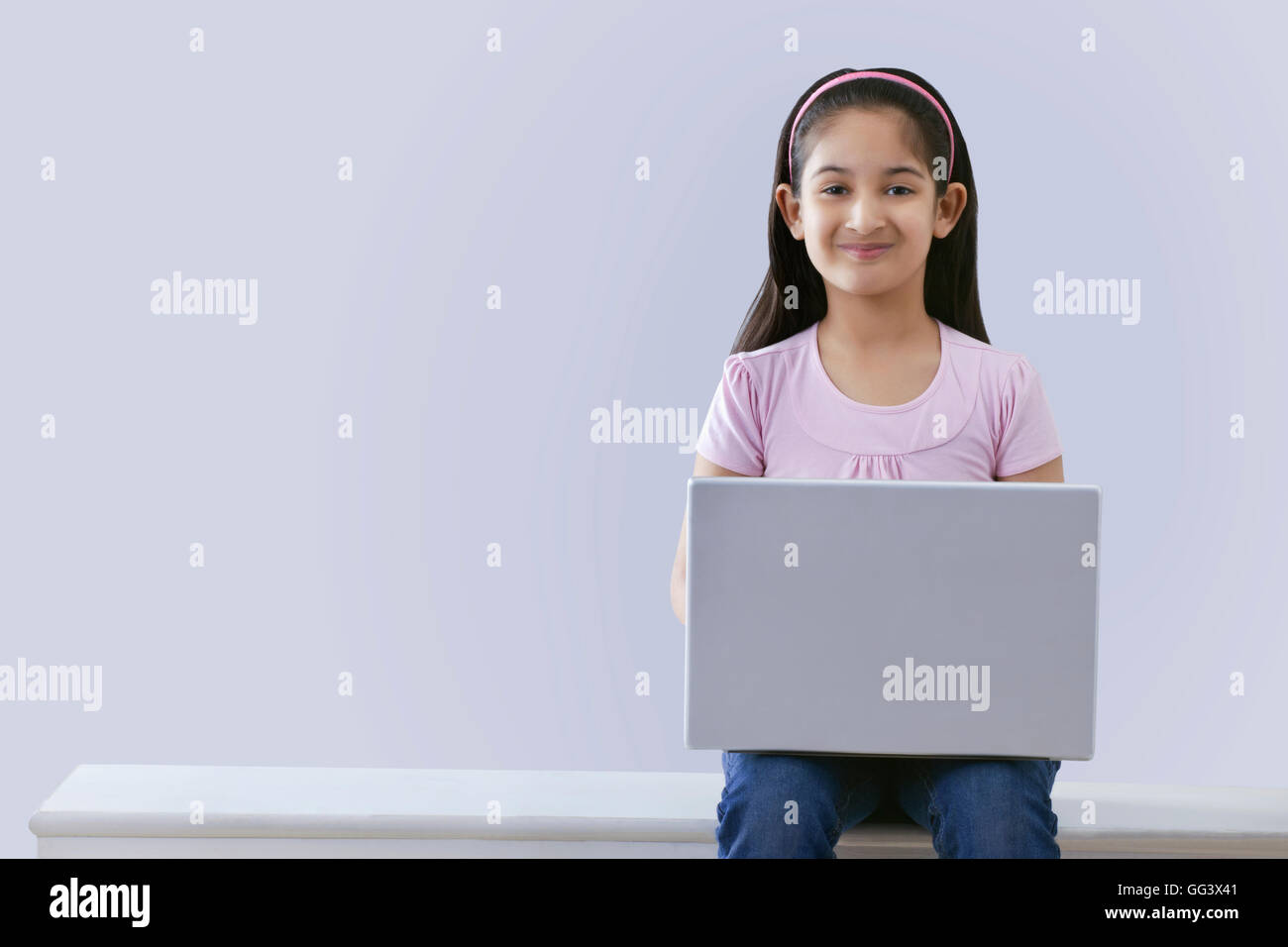 Kleines Mädchen mit einem Laptop zeigt Stockfoto