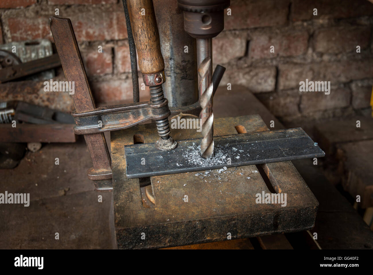 Verschieben von Bohrer bohren eine Metallplatte in einer alten Werkstatt Stockfoto