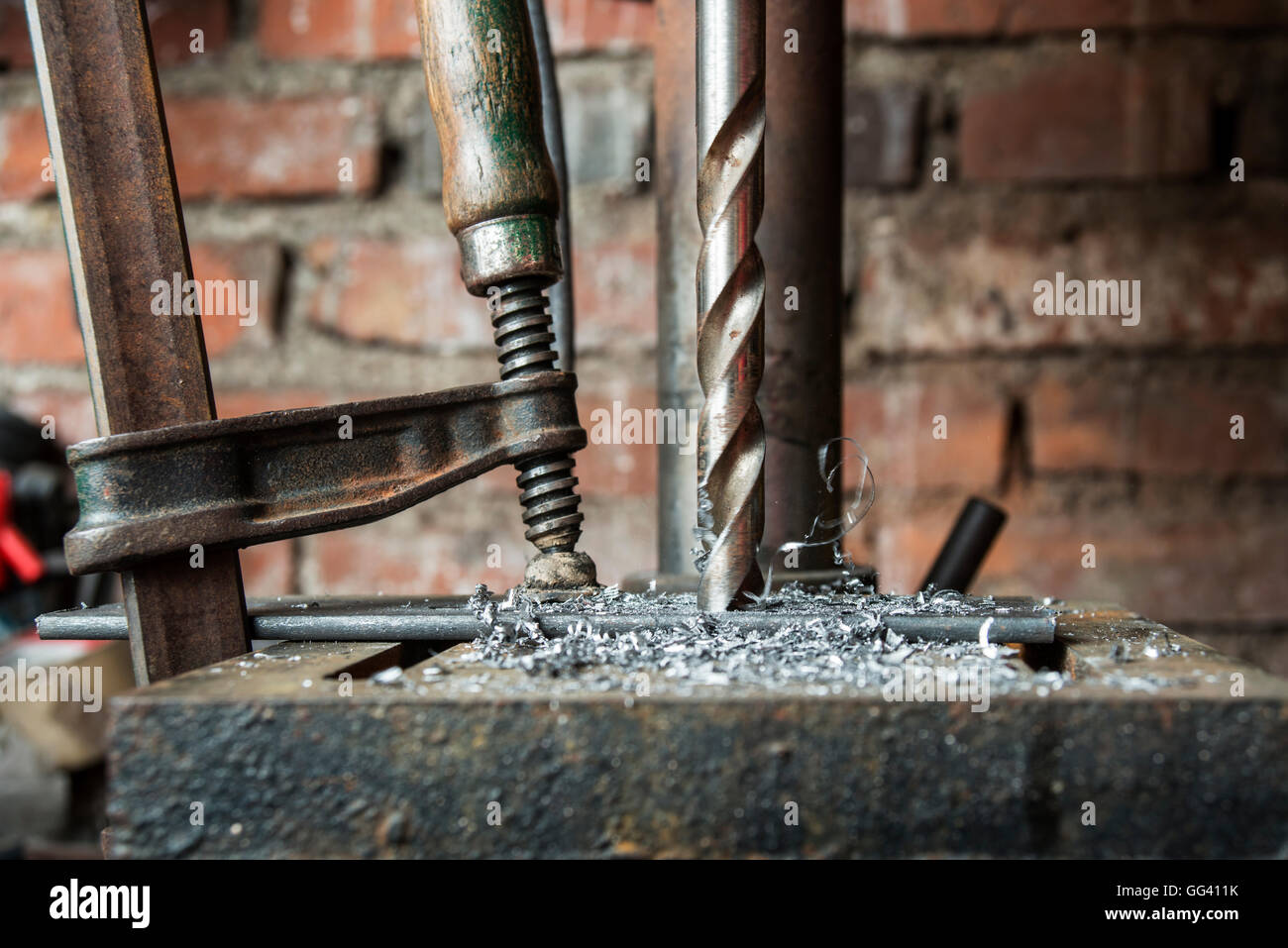 Verschieben von Bohrer bohren eine Metallplatte in einer alten Werkstatt Stockfoto