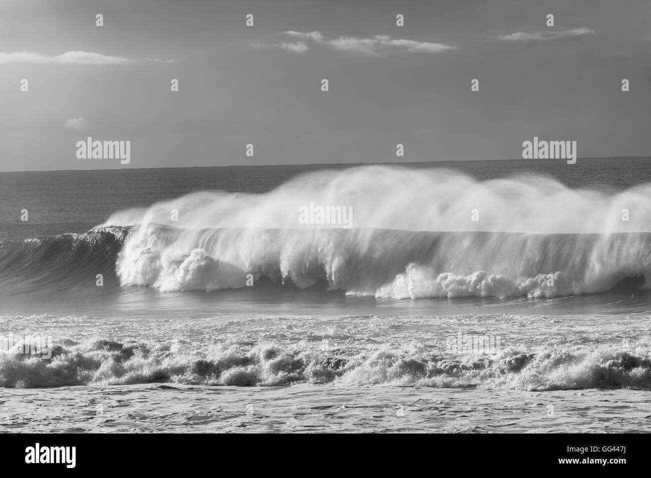 Ozeanwellen, die Kraft des Wassers entlang der felsigen Küste Sturm Strandwetter in schwarz-weiß Kontraste... Stockfoto