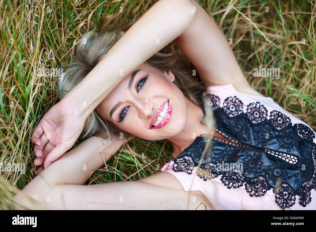 schöne Frau lächelnd und liegen auf dem Rasen Stockfoto