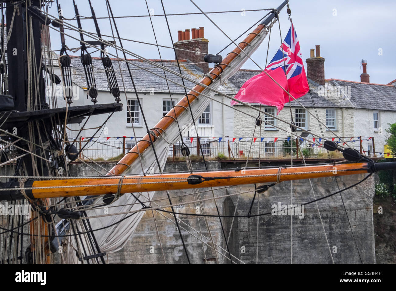 Takelage eines Segelschiffes im Hafen von Charlestown, Cornwall, fliegen die Red Ensign Stockfoto