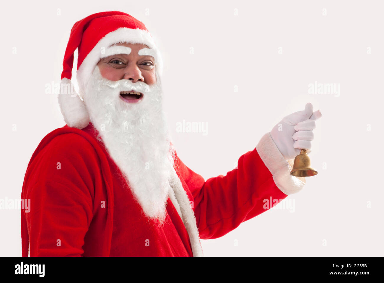 Porträt von lächelnden Weihnachtsmann mit Glocke vor weißem Hintergrund hautnah Stockfoto