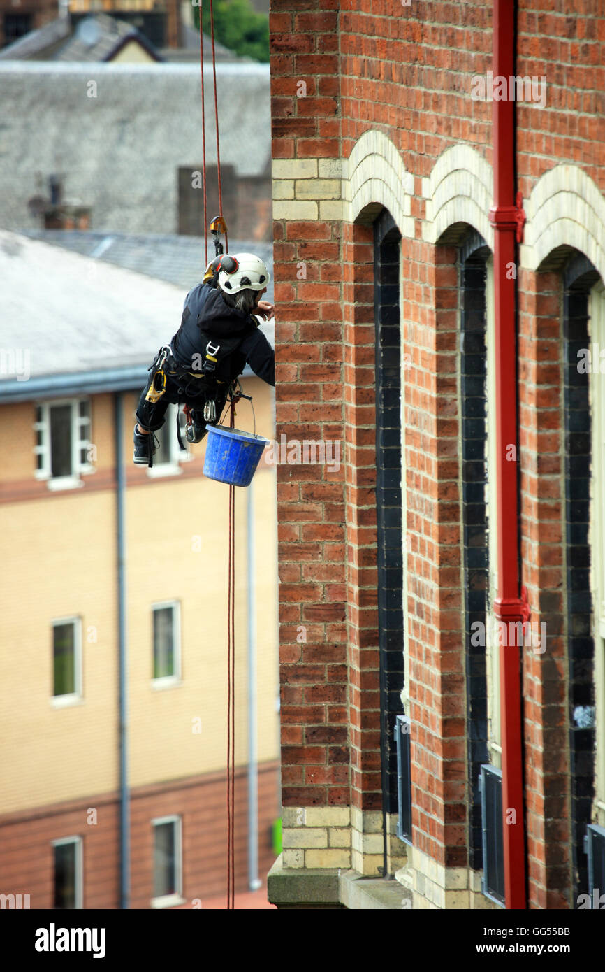 Abseiler arbeiten am Mauerwerk auf ein Gebäude in Paisley, Schottland zeigen Stockfoto