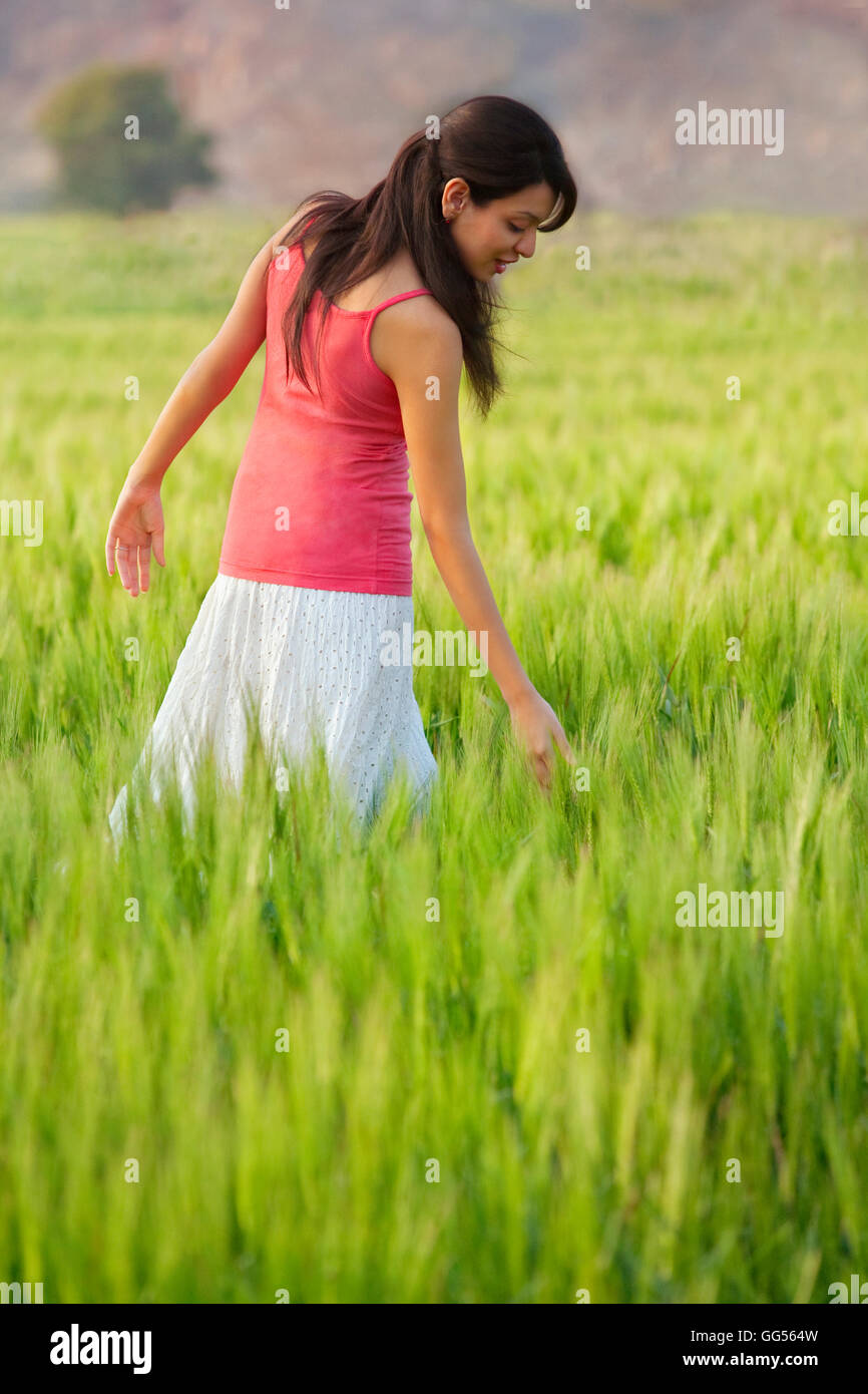 Frau zu Fuß durch ein Feld Stockfoto