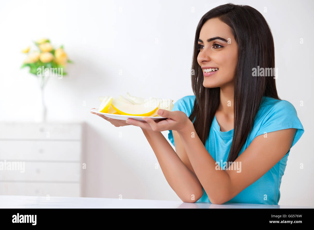 Schöne junge Frau, die Halteplatte mit Scheiben von Melone zu Hause Stockfoto