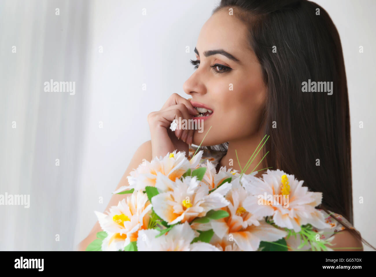 Nachdenkliche junge Frau mit Blumenstrauß Stockfoto