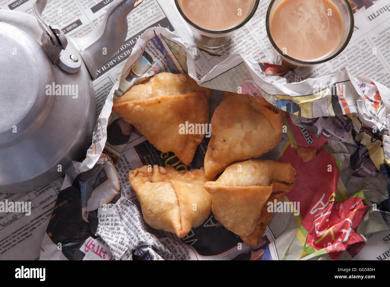 Direkt über die Aufnahme von frischem Samosas, Tee und Wasserkocher auf Tisch Stockfoto