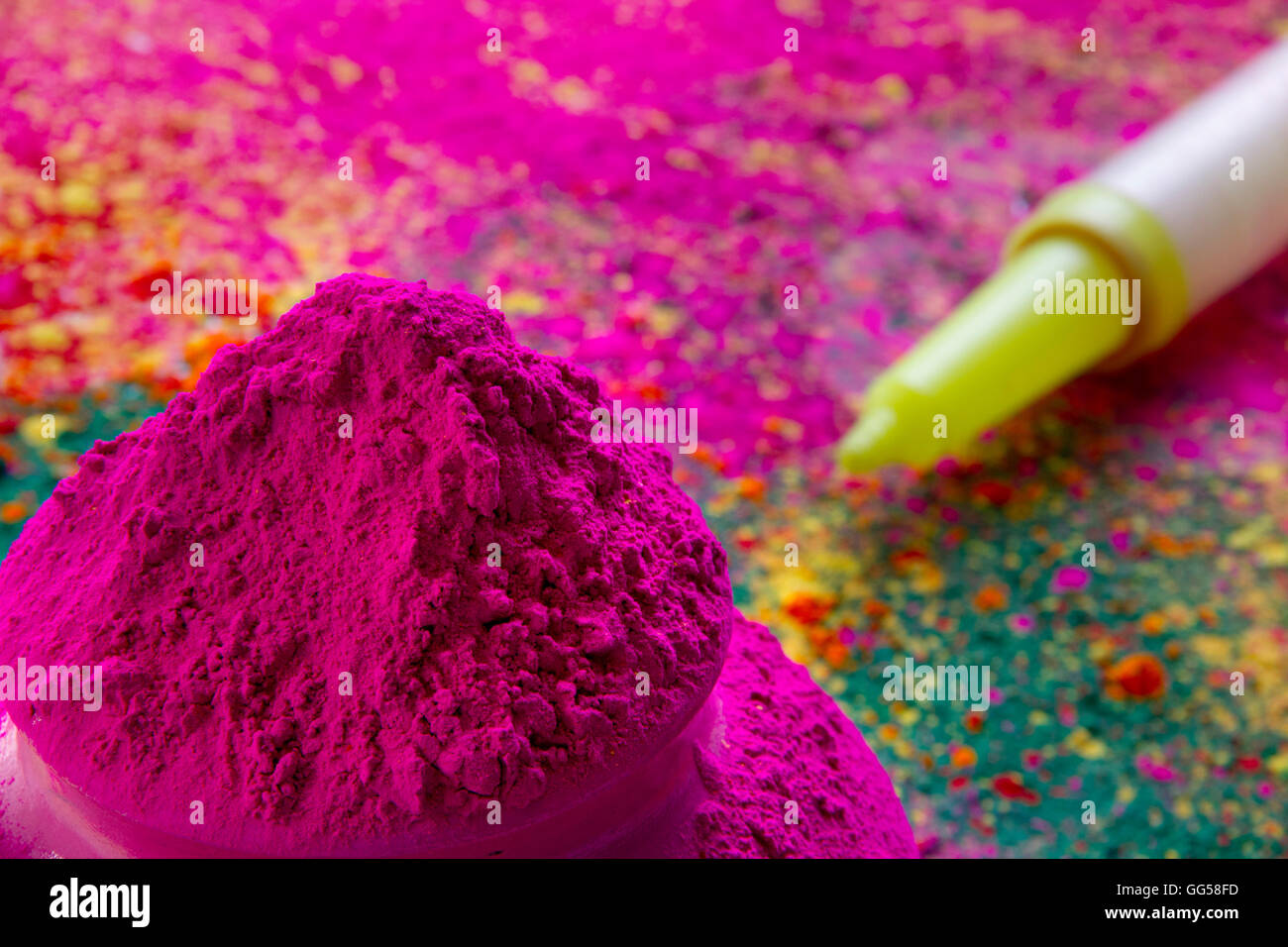Nahaufnahme von rosa Holi Farbpulver mit Spritzpistole im Hintergrund Stockfoto