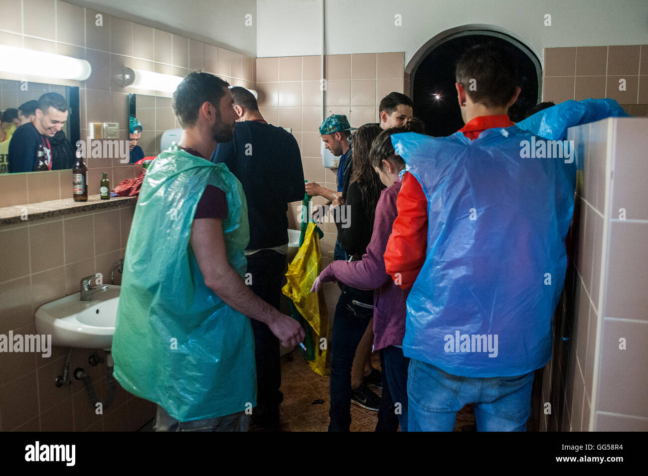 Musik-Festival. Menschen, die das Musikfestival am Meer in Kroatien genießen. Nehmen Zuflucht vor dem Regen auf der Toilette. Stockfoto