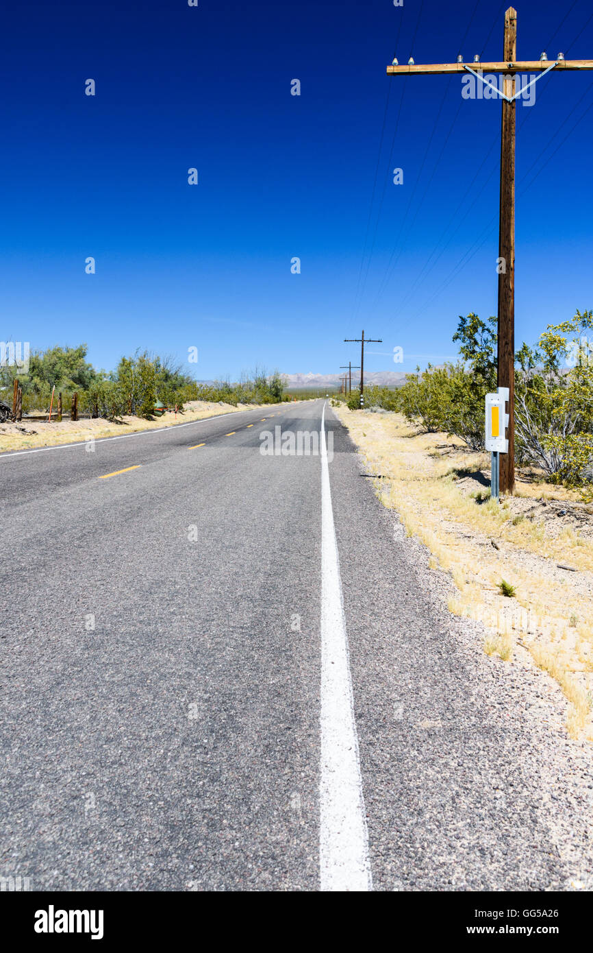 Telegraph Pole laufen entlang einer langen geraden Roadi n der Mojave National Preserve Stockfoto