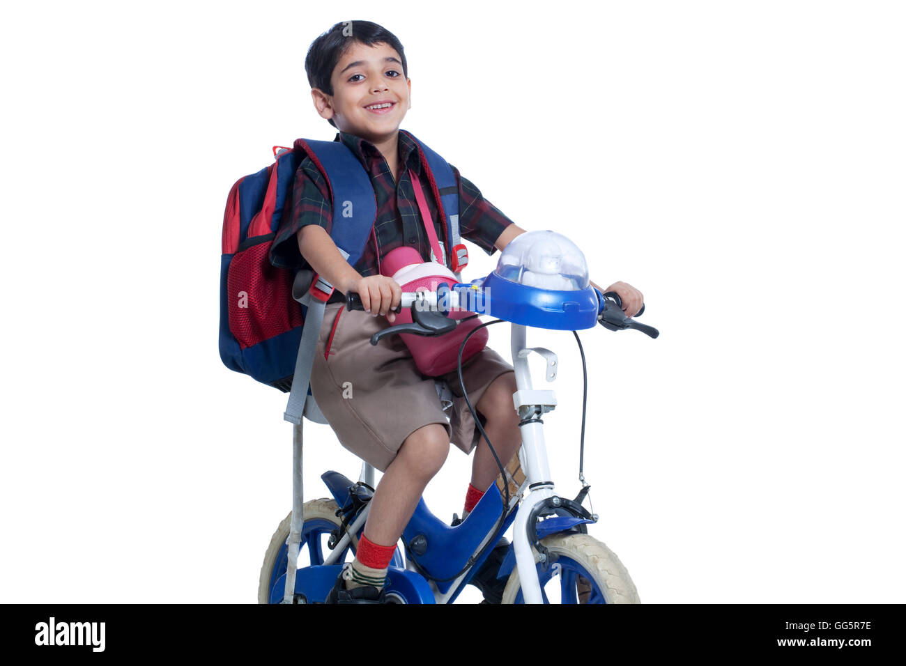 Glücklich Schule Kind Reiten Fahrrad vor weißem Hintergrund Stockfoto