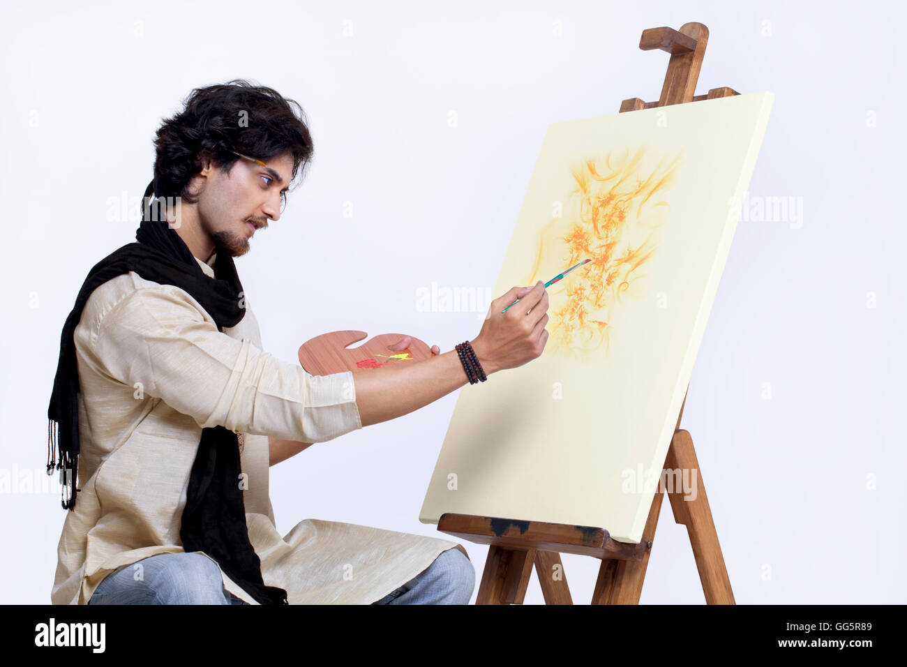Junge Künstler Malerei vor weißem Hintergrund Stockfoto