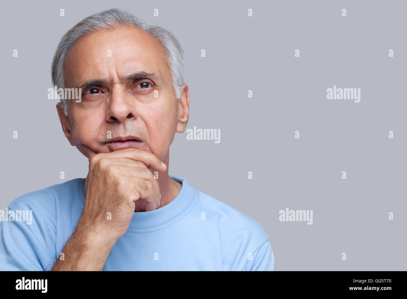 Senior woman denken mit Hand am Kinn Stockfoto