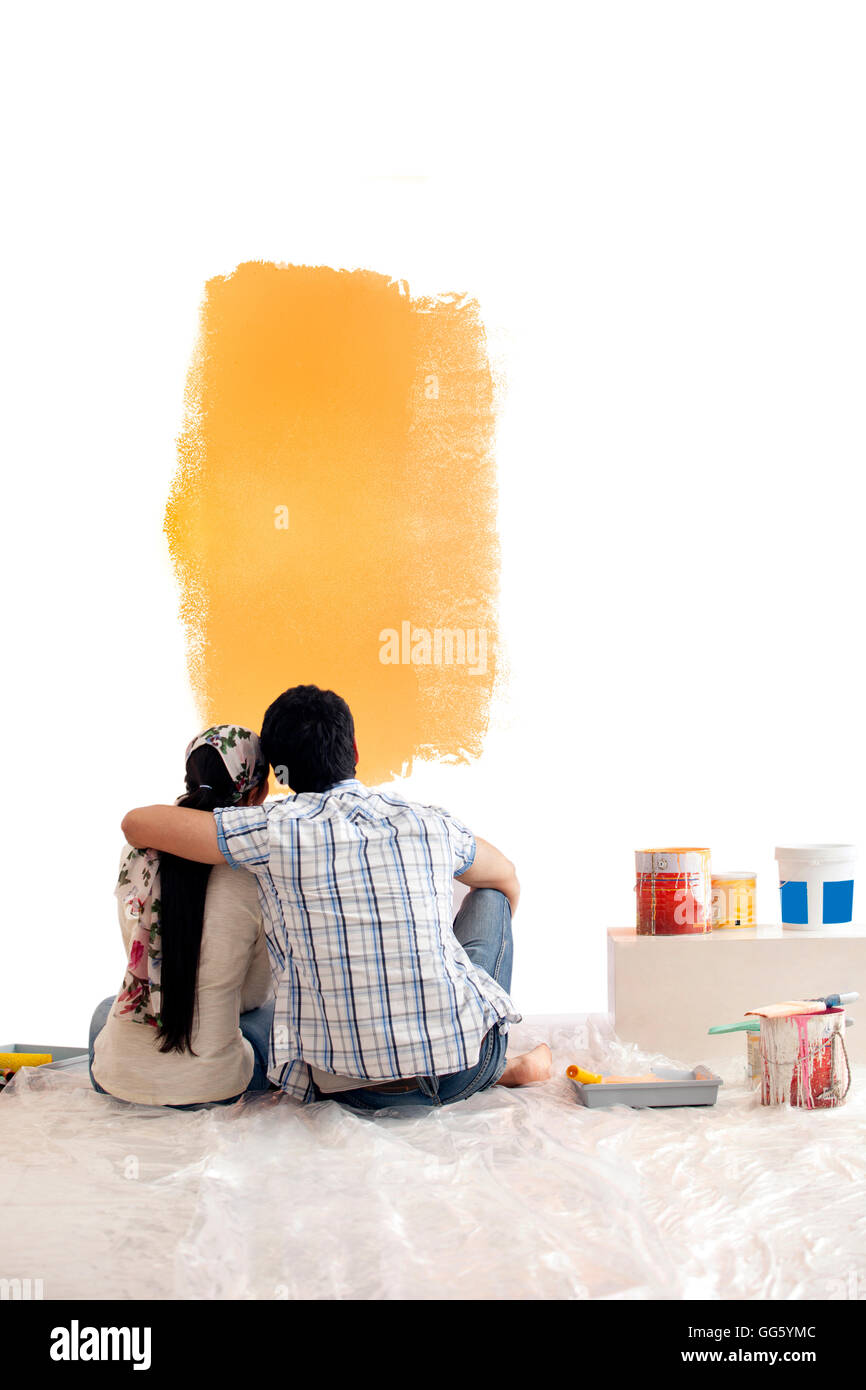 Rückansicht des jungen Paares betrachten Farbmuster zusammen an der Wand Stockfoto
