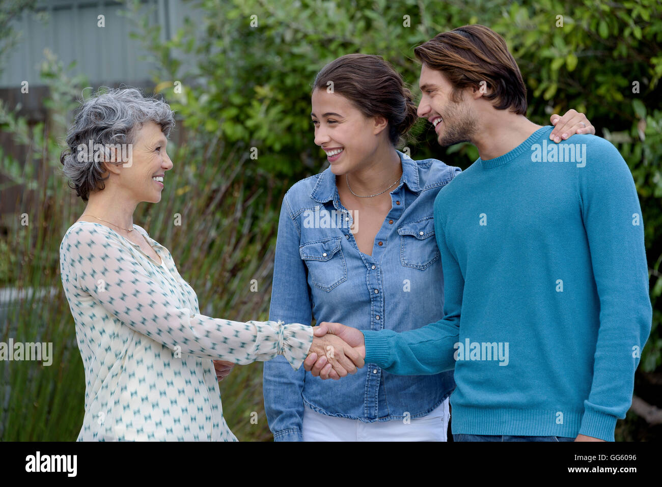 Glücklich Reife Frau treffen mit jungen Paar außerhalb Stockfoto