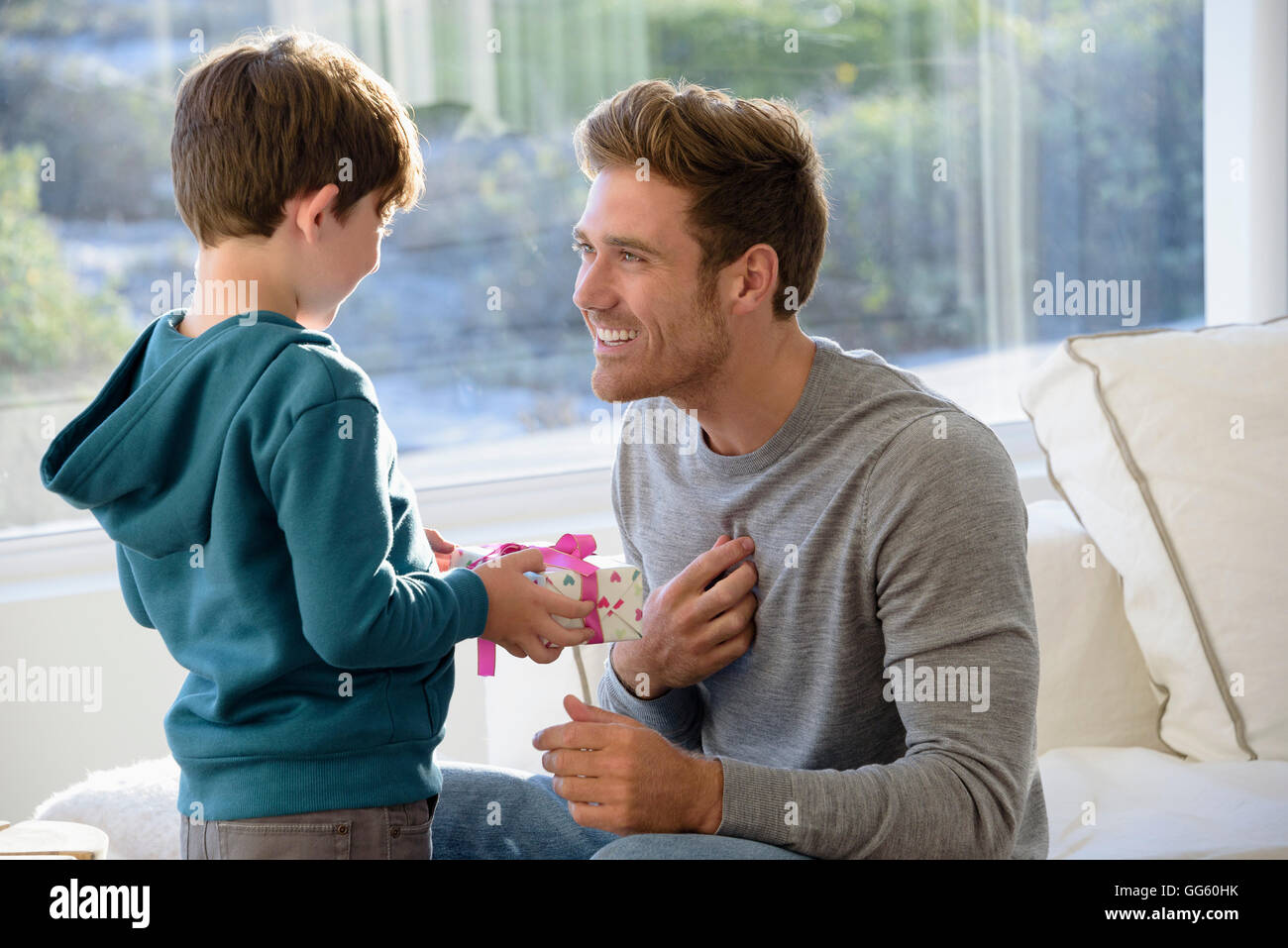 Glücklicher Vater und Sohn mit Geburtstagsgeschenk Stockfoto