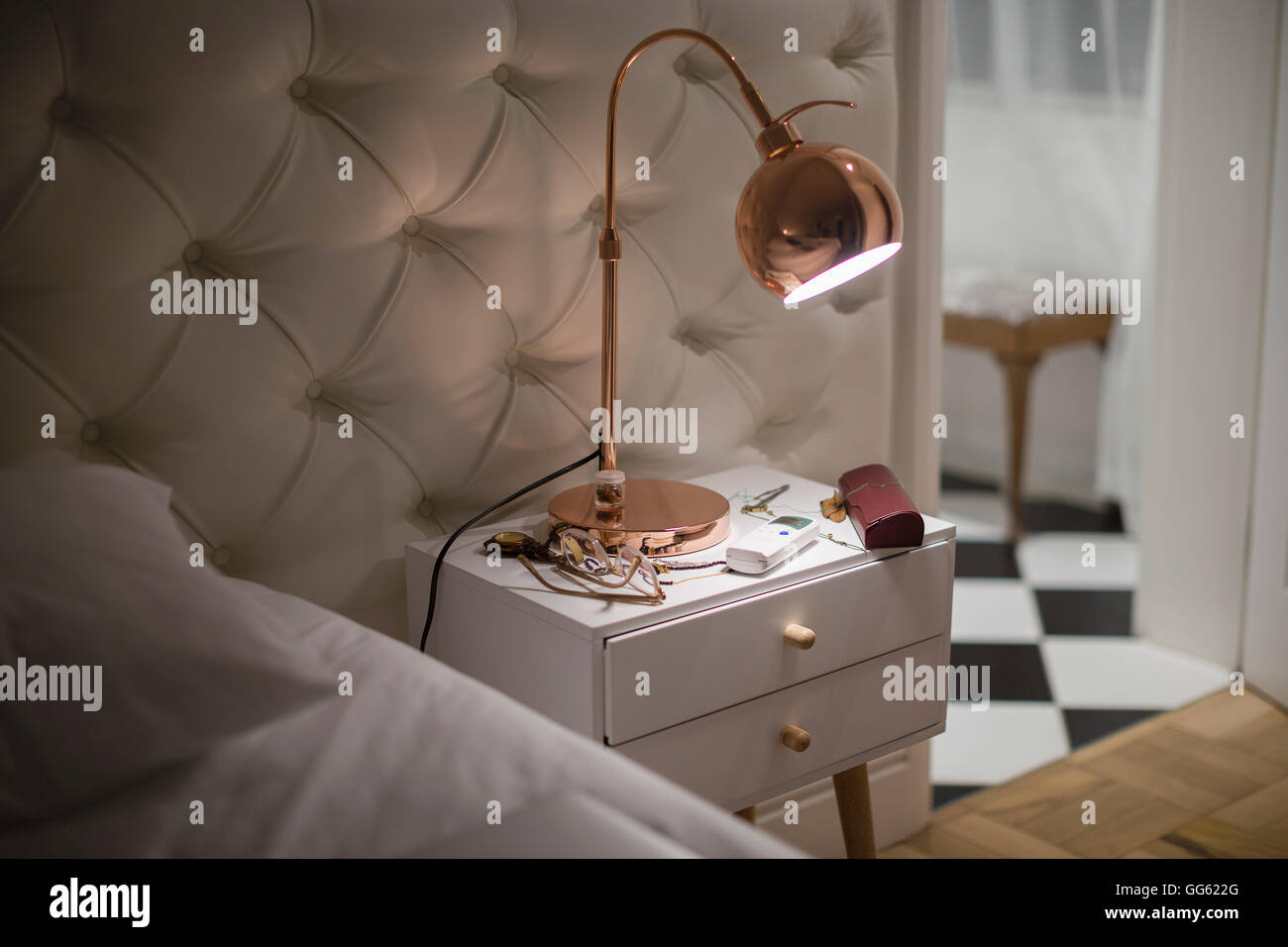 Beleuchtete Lampe auf dem Nachttisch im Schlafzimmer Stockfoto