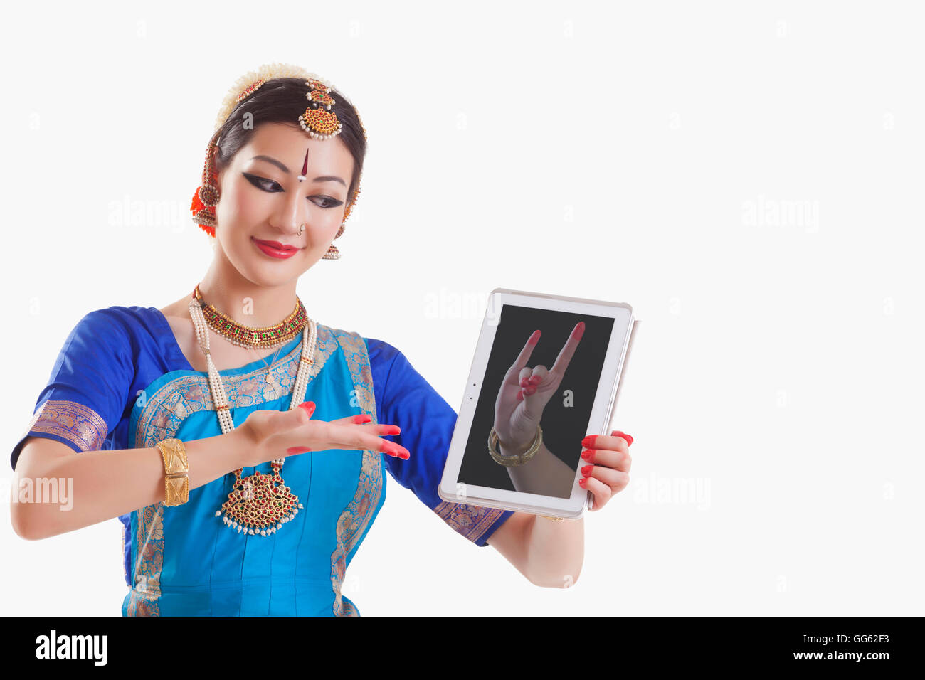 Bharatanatyam-Tänzerin zeigt Simhamukha Mudra auf digital-Tablette auf weißem Hintergrund Stockfoto