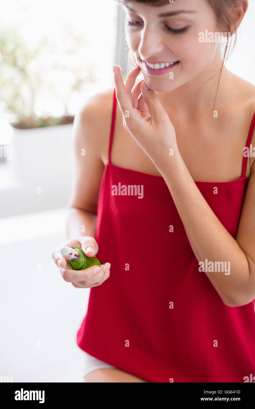 Schöne Frau, die Anwendung der Feuchtigkeitscreme auf Gesicht im Badezimmer Stockfoto