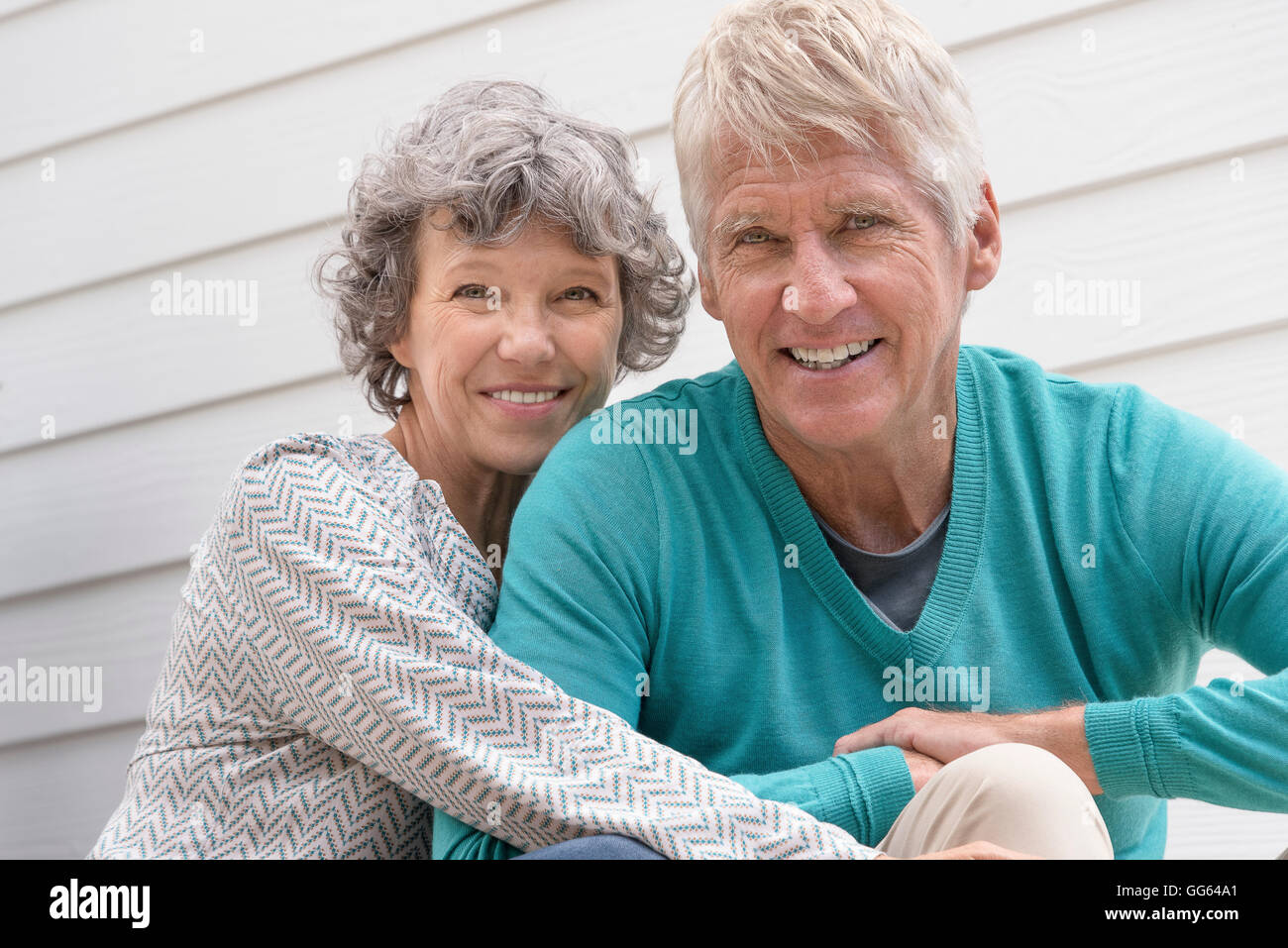 Gerne älteres paar sitzen außerhalb Haus Stockfoto